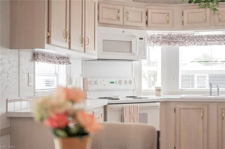 Kitchen featuring white appliances, sink, and plenty of natural light