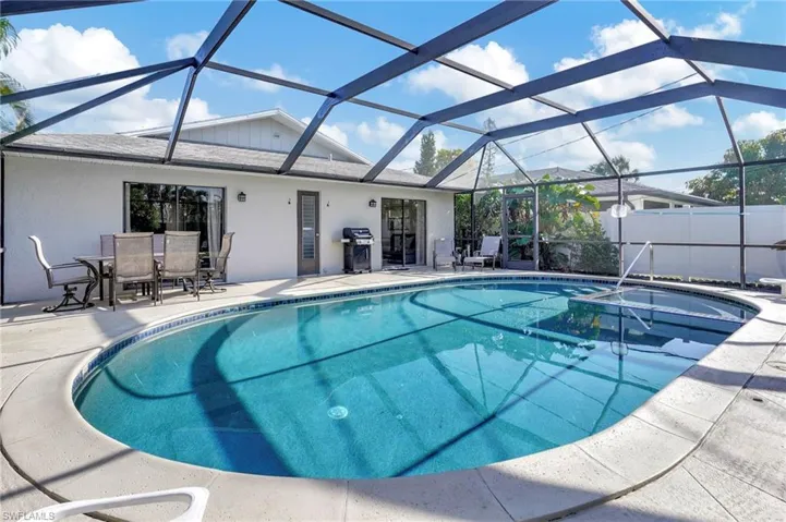 View of swimming pool featuring a grill, a patio area, and glass enclosure