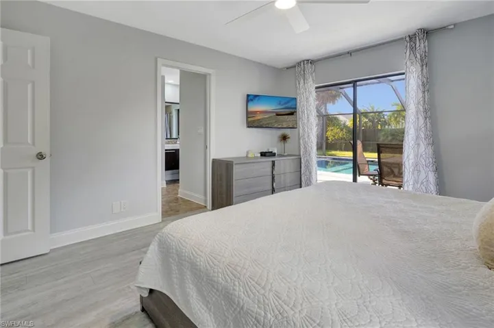 Bedroom with access to outside, wood-type flooring, ceiling fan, and ensuite bathroom