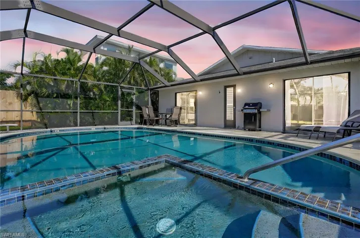 Pool at dusk with a patio area and a lanai