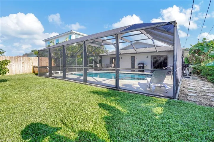 View of swimming pool featuring a yard, a lanai, and a patio