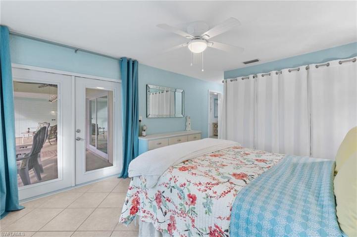 Primary bedroom with french doors to the lanai/pool area.