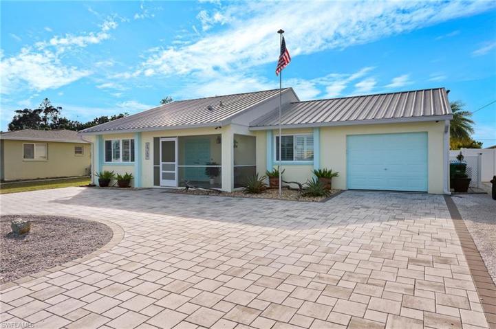 Front view of home with U-shaped paver driverway.