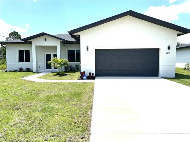 Ranch-style home with a front yard and a garage