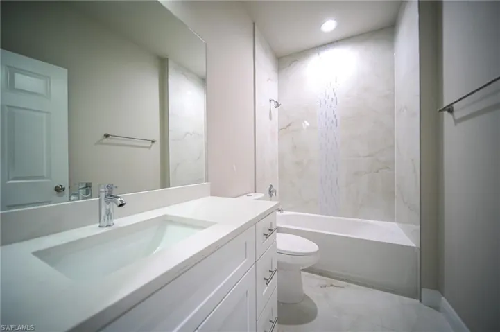 Full bathroom featuring vanity,  shower combination, recessed lighting, toilet, and marble finish floor