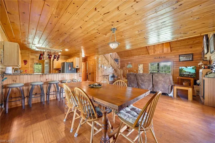 Dining area featuring wood walls, light wood-style floors, and wood ceiling