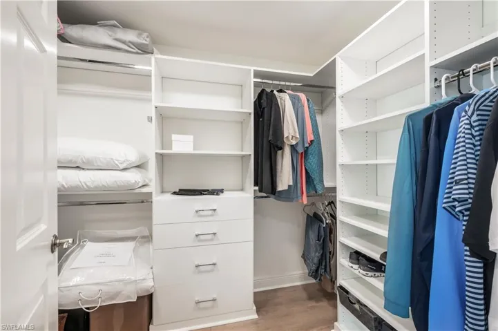 Spacious closet with hardwood / wood-style flooring