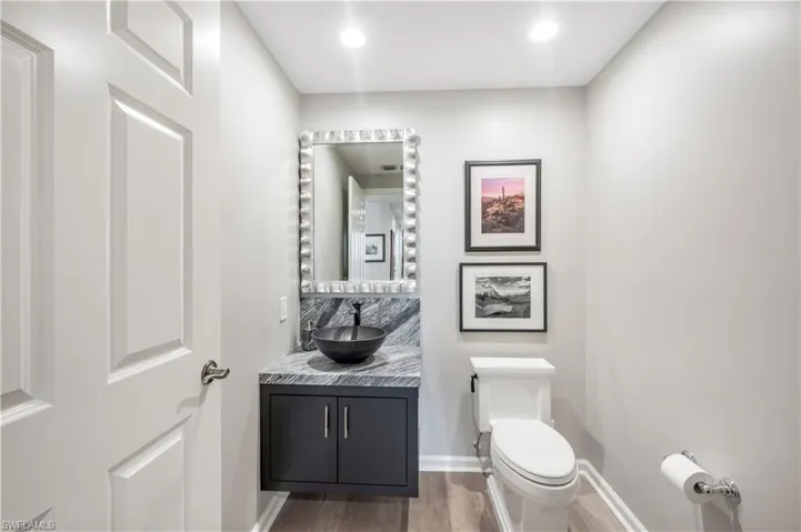 Bathroom with vanity, hardwood / wood-style flooring, and toilet