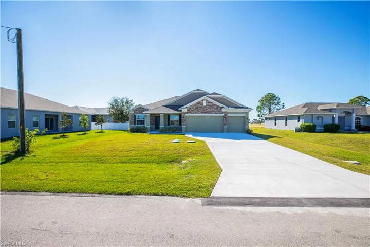 Ranch-style home with a garage and a front lawn