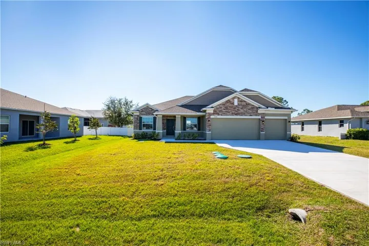 View of front facade with a garage and a front lawn
