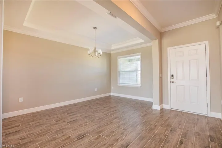 Unfurnished living room with dark hardwood / wood-style floors, ornamental molding, and sink