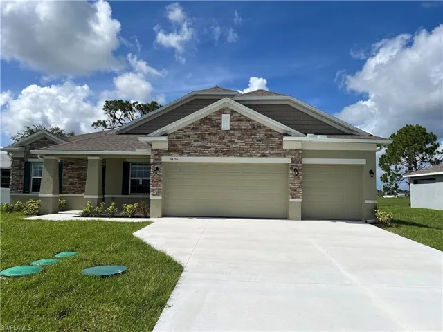 View of front of home featuring a front yard, a porch, and a garage