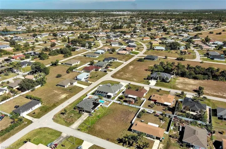 Aerial view of property and surrounding area with nearby suburban area