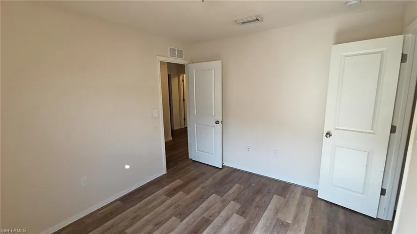 Neutral-toned walls complement the wood-finish flooring