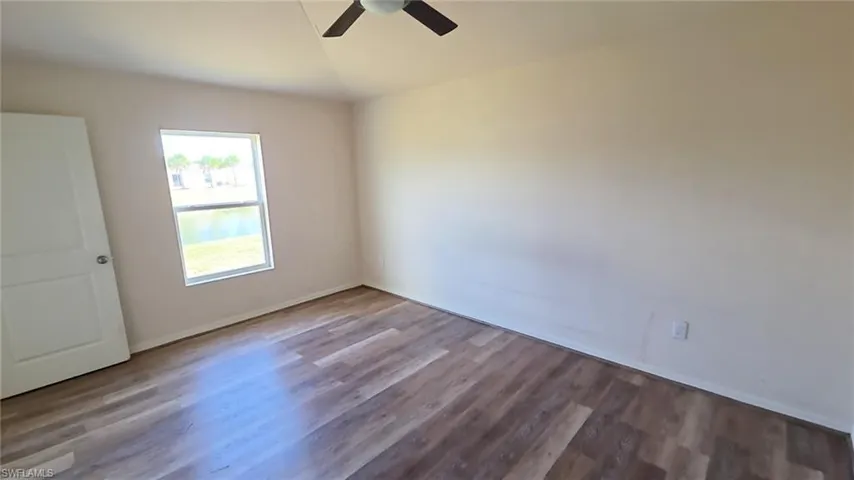 Room featuring wood-finish flooring, a ceiling fan, and white walls