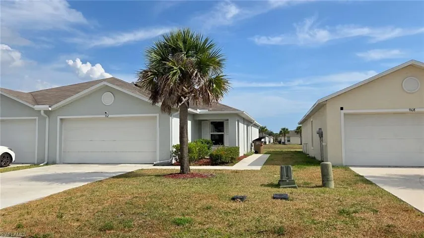 Single-story residence featuring a light-colored exterior and an attached garage