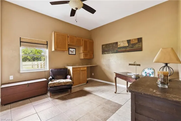 Office area in in-law home featuring ceiling fan and light tile flooring