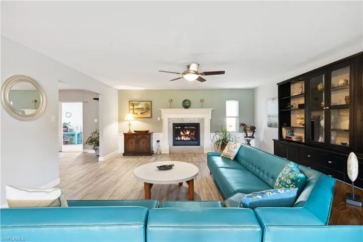 Living room featuring ceiling fan, a fireplace, and tile