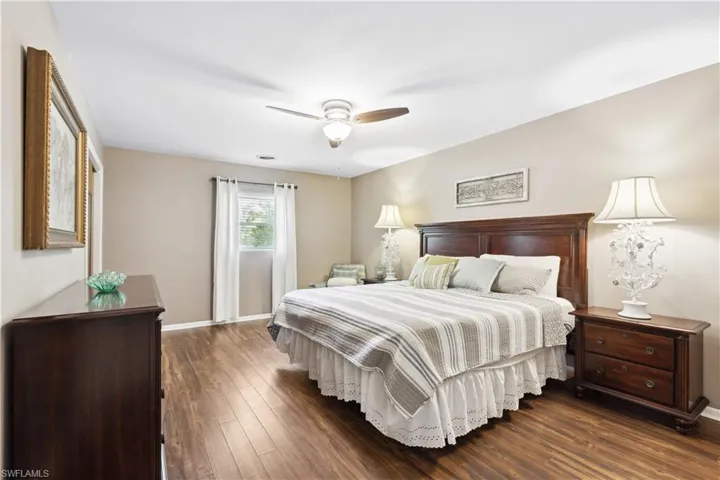 Bedroom with dark wood-type flooring and ceiling fan