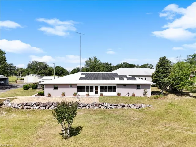 Front of main house with a lawn and solar panels