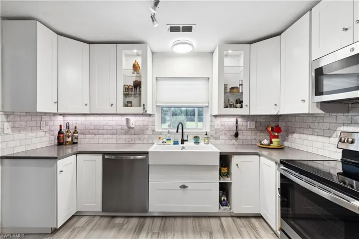 Kitchen featuring tasteful backsplash, light wood-type flooring, and stainless steel appliances