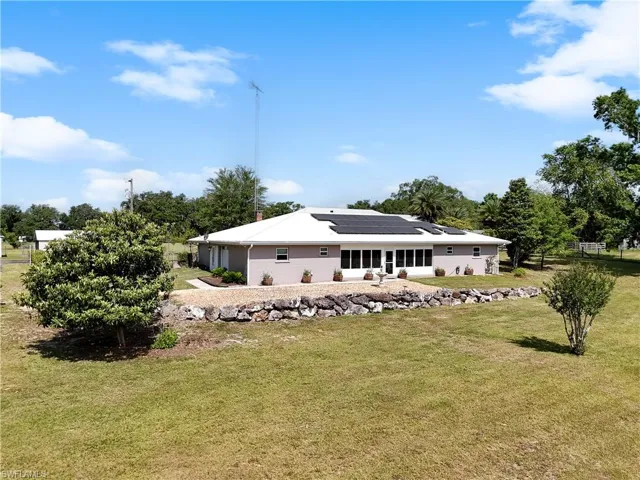 Front of property featuring a yard and solar panels