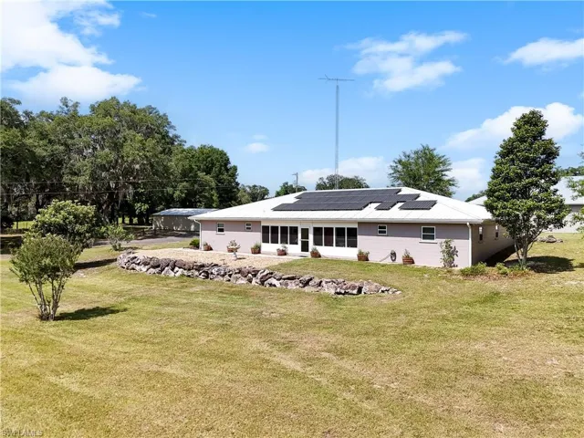 Front view of main house featuring a lawn and solar panels