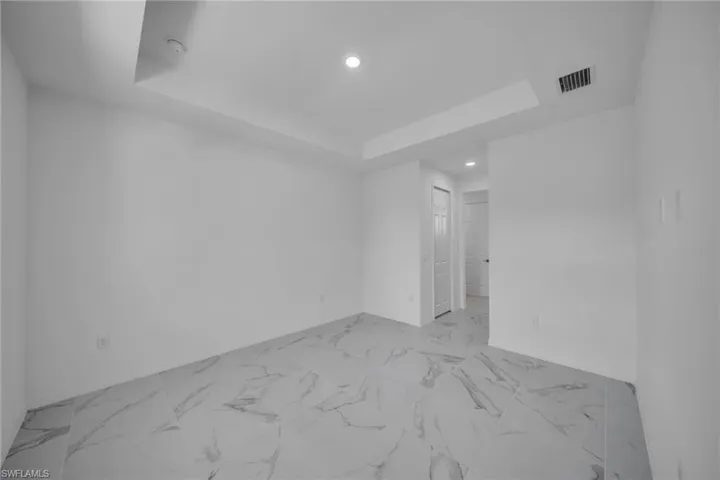 MASTER ROOM featuring large format marble-look tile flooring, crisp white walls, and a recessed ceiling with integrated lighting