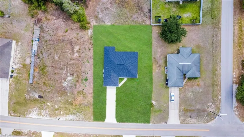 OVERSIZED LOT EAGLE'S EYE VIEW! Newly constructed residence featuring a dark shingle roof and a concrete driveway