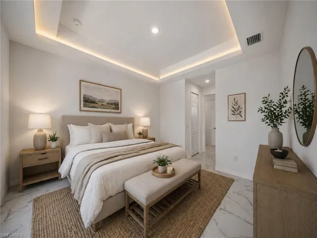 MASTER Recessed lighting and cove lighting illuminate a spacious room featuring large format marble-look tile flooring
