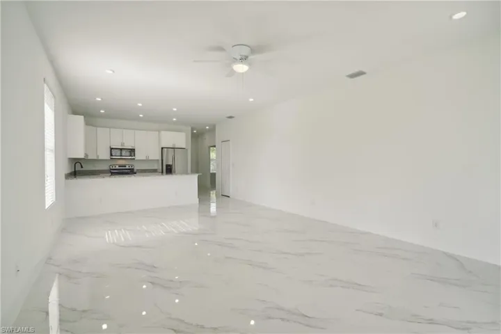 Unfurnished living room featuring sink and ceiling fan