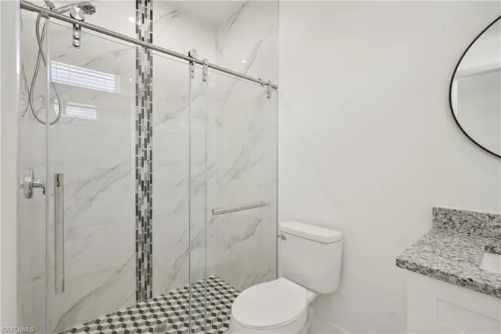 Bathroom with walk in shower, vanity, and toilet