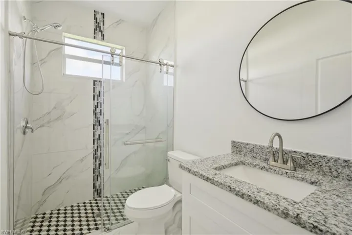 Bathroom with walk in shower, vanity, and toilet