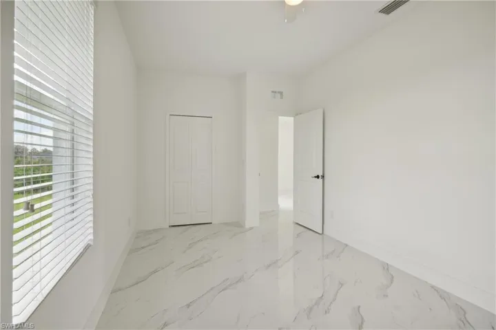 Unfurnished bedroom with ceiling fan and a closet