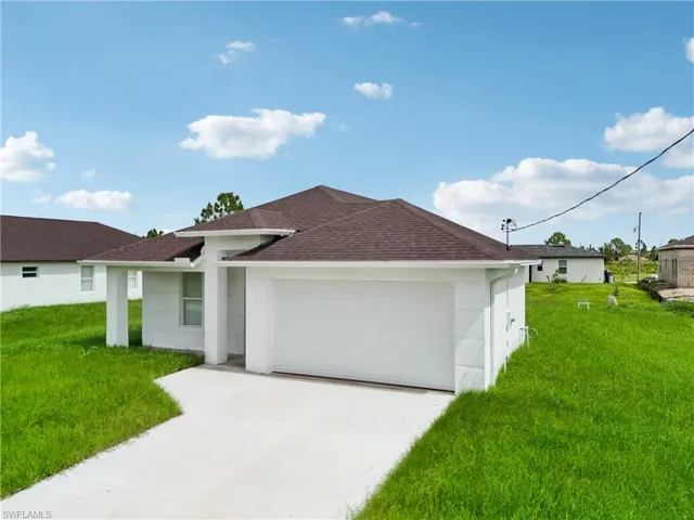 Single story home featuring a front yard and a garage