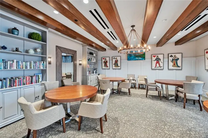 Dining area with beamed ceiling, a chandelier, and built in shelves