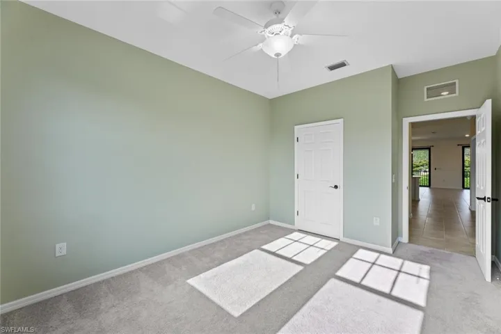 Bedroom with ceiling fan and light carpet