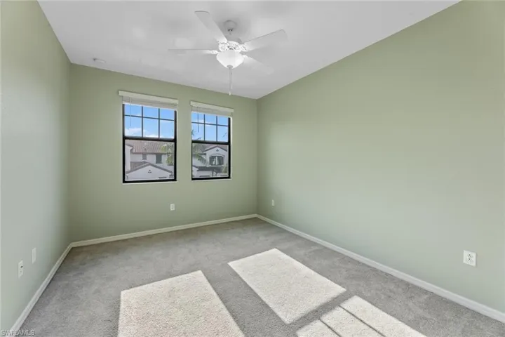 Carpeted empty room featuring ceiling fan