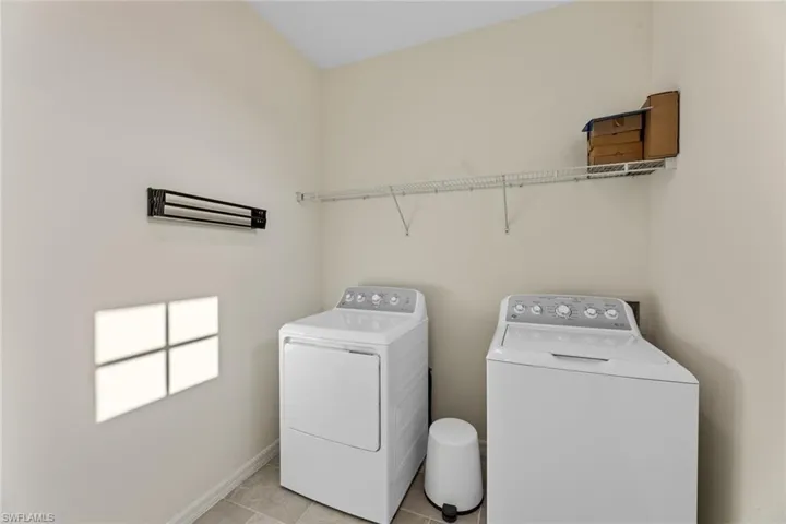 Laundry room featuring washer and clothes dryer and light tile floors