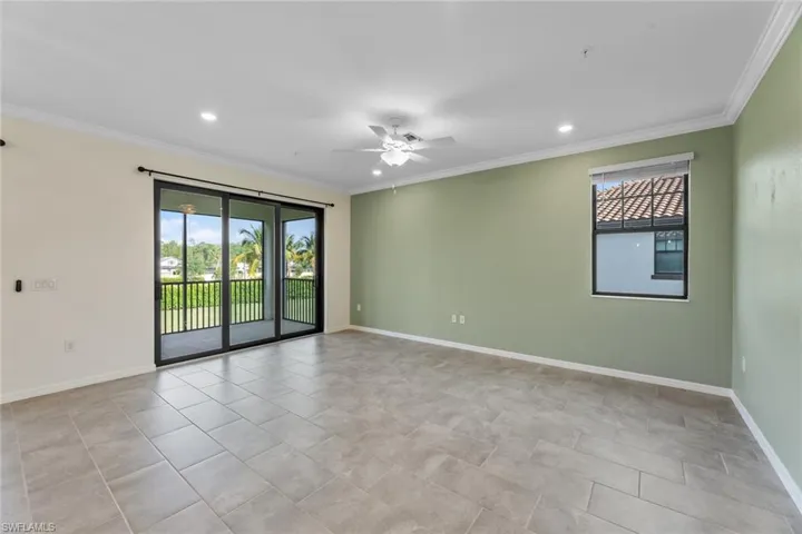 Tiled empty room with crown molding and ceiling fan