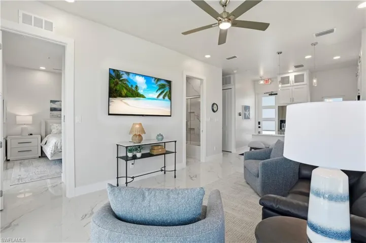 Living area with light marble finish flooring, ceiling fan, and recessed lighting - Virtually Edited Image