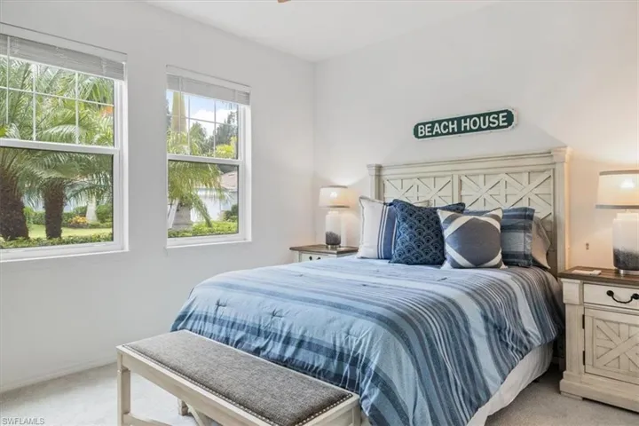 Bedroom featuring multiple windows and light colored carpet