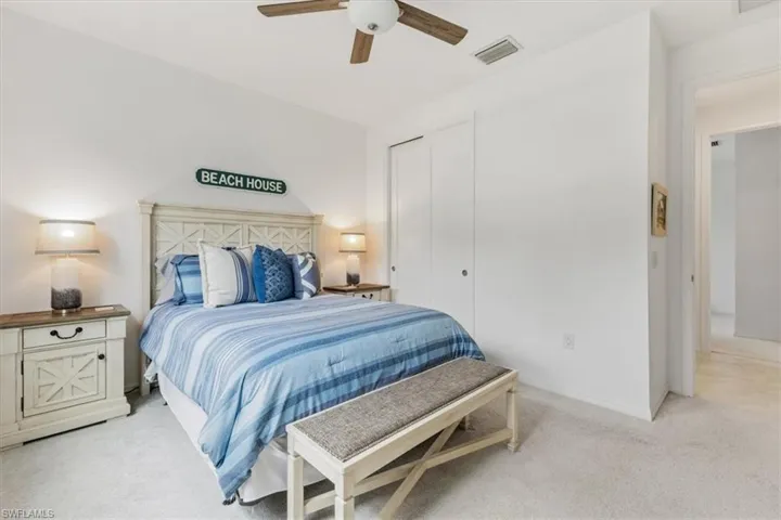 Carpeted bedroom with a closet and ceiling fan