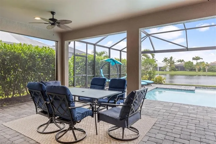 Sunroom / solarium featuring plenty of natural light, a water view, and ceiling fan