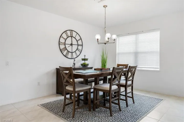 Tiled dining room featuring an inviting chandelier