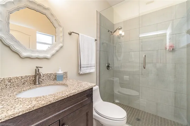 Bathroom with vanity and walk-in shower near pool area