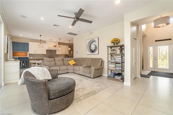 Tiled living room featuring ceiling fan and recessed lighting