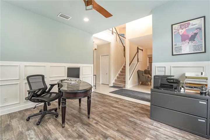 Den/office space with hardwood / wood-style floors and ceiling fan
