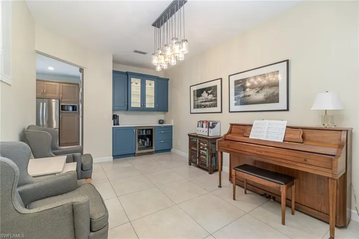 Tiled dining room featuring a notable chandelier and bar area