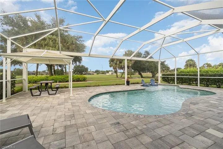 View of swimming pool featuring a large lanai and a patio area
